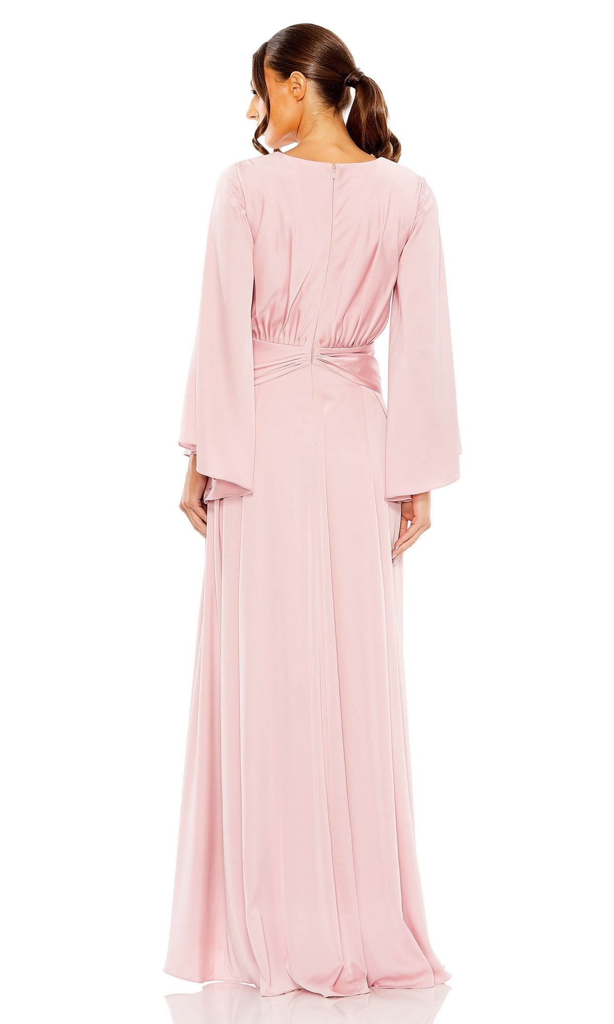 A woman stands with her back to the camera, wearing the pink Long Formal Dress 55993 by Mac Duggal. This floor-length gown features elegant draping and long sleeves, and she has her hair in a low ponytail.